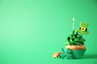 Decorated cupcake on green background, space for text. St. Patrick's Day celebration