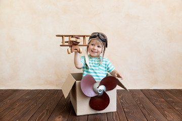 Wall Mural - Happy child playing with toy airplane