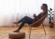 © Prostock-studio - Calm girl drinking coffee, relaxing near window at home