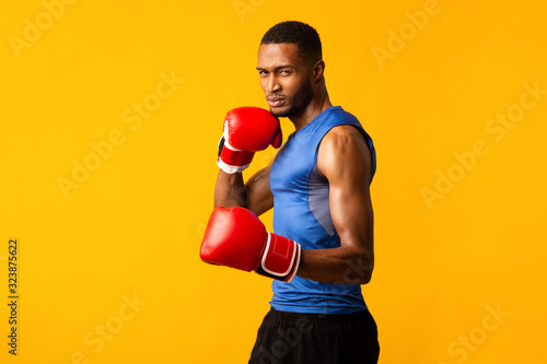 Foto Confident afro fighter demonstrating classical boxing stance