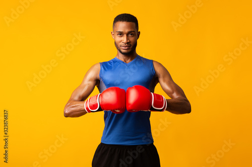 Handsome afro sportsman ready for fight at orange studio Fototapete
