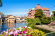 © olrat - View from the Saint-Thomas bridge over the Petite France historic quarter in Strasbourg, France, with the river Ill, the former water mills and potted flowers in the foreground.