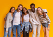 © Prostock-studio - Friendly group of international students smiling over yellow background