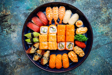 Set Of Sushi And Maki With Soy Sauce Over Blue Stone Background. Top View With Copy Space