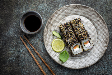 Wall Mural - Set of sushi and maki with soy sauce over blue stone background. Top view with copy space