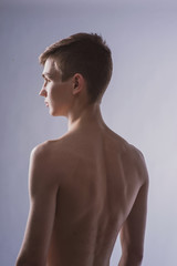 Wall Mural - Portrait of a young brown-haired man with a naked torso, a view from the back and a full-face portrait