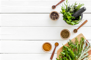 Wall Mural - Making spices. Herbs in motar and dry flavorings on white wooden table top-down copy space