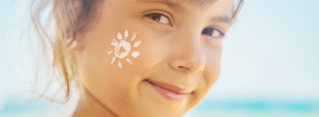 Poster - Sunscreen on the skin of a child. Selective focus.