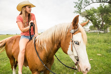 Western Girl Leading And Riding Horse Bareback In Pasture. Bridger, Montana, USA