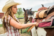 © MACO - Young cowgirl saddling a horse. Bridger, Montana, USA