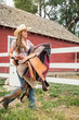 © MACO - Young cowgirl carrying horses saddle. Bridger, Montana, USA