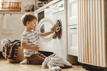 Happy  Householder Child Boy In Laundry   With Washing Machine.