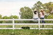 © MACO - Two western girls sitting on a fence, laughing. Bridger, Montana, USA