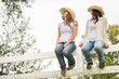© MACO - Two western girls sitting on a fence, laughing. Bridger, Montana, USA
