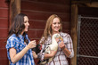 © MACO - Two western girls laughing, next to barn, holding chickens. Bridger, Montana, USA