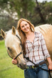 © MACO - Girl pets and leads a mare in a pasture. Bridger, Montana, USA
