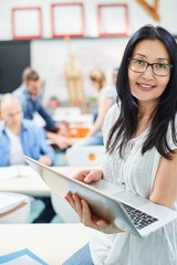 asiatische frau als dozentin mit laptop computer