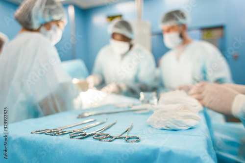 Fotografía Tools for the operation in the foreground and a team of surgeons in the backgrou