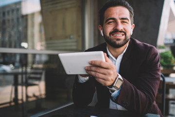 Wall Mural - Cheerful Hispanic entrepreneur with tablet looking at camera