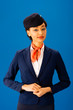 © LIGHTFIELD STUDIOS - smiling african american flight attendant  looking at camera isolated on blue