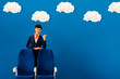 © LIGHTFIELD STUDIOS - smiling african american flight attendant showing like near seat on blue background with clouds