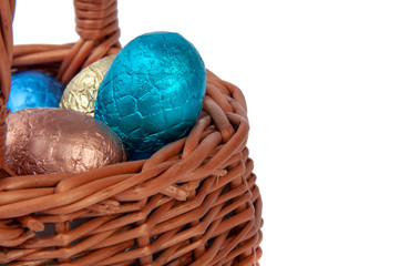 chocolate easter eggs in wooden basket isolated on the white