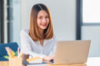 © Songsak C - Portrait of pretty young woman using her laptop in the office.