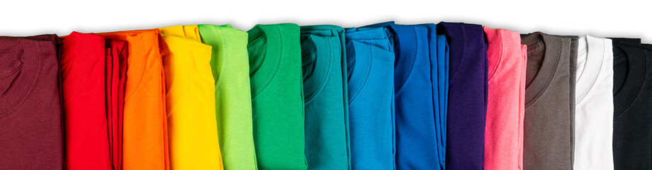 wide panorama row of many fresh new fabric cotton t-shirts in colorful rainbow colors isolated. pile