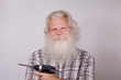 Senior thickset Caucasian smiling man with splendid grey hair and beard on grey background with electric drill and big borer in hand. Attractive elderly European handsome happy people close up.