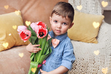 Cute Little Boy Gentleman In A Blue Denim Shirt And Peach Bow Tie Holding A Bouquet Of Beautiful Pink Tulips.	