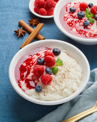 Wall Mural - Rice pudding. French milk rice dessert with raspberries, blueberries, berries, jam.