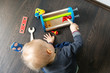 © ronstik - child playing with wooden toy tool box on the floor at home