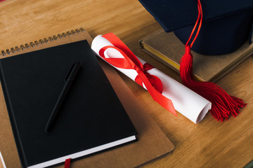Poster - Notebooks, pen, diploma and graduation cap on wooden background