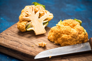 Wall Mural - Yellow Cauliflower Cabbage on Cutting Board. Market Fresh Organic Food. Plant Based Diet