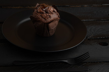 Poster - Chocolate cupcake on black wooden background