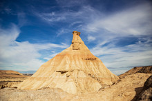 Big Brown Cliff With Colorful Blue Sky And White Clouds On Background At Bardenas Reales At Spain
