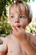 Little Boy Eating A Berry