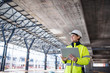 © Halfpoint - A woman engineer with tablet standing on construction site, working.