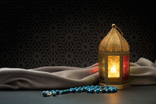 Ramadan Lantern And Blue Rosary Beads In Front Of Dark Arabesque Background.