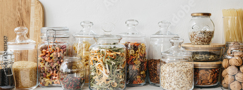 Various cereals and seeds in glass jars on the white textured background Poster Mural XXL