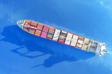 Large container ship sailing blue sea. Top aerial view