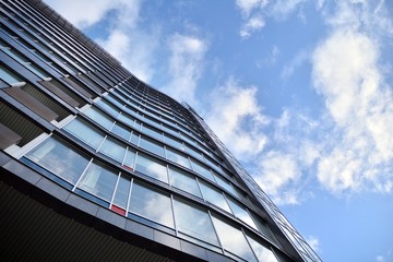 Modern office building wall made of steel and glass with blue sky