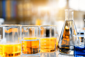 Wall Mural - flask containing chemical liquid with beaker and lab glassware in chemical laboratory background, sc