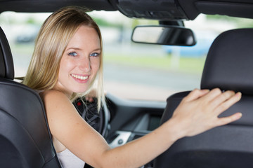 smiling woman sitting in a car and looking back