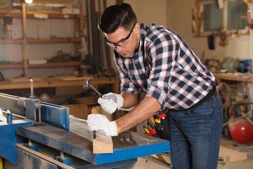 Sticker - Professional carpenter working with wooden plank in workshop