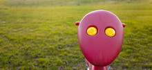 Kids Toy With A Face And Yellow Eyes Out In Green Grass