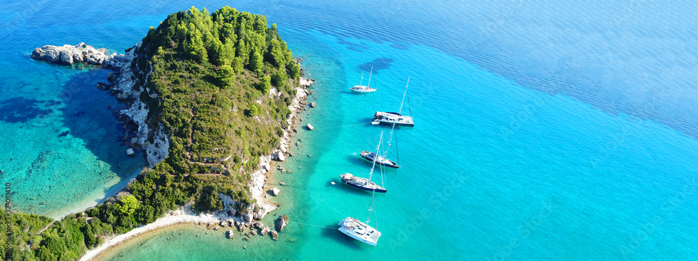Aerial drone ultra wide photo of breathtaking turquoise exotic bay of blue lagoon in island of Paxos visited by sail boats, Ionian, Greece - obrazy, fototapety, plakaty 