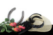 Kentucky Derby photo of a fascinator hot with red roses and a horseshoe. on a black table with white background