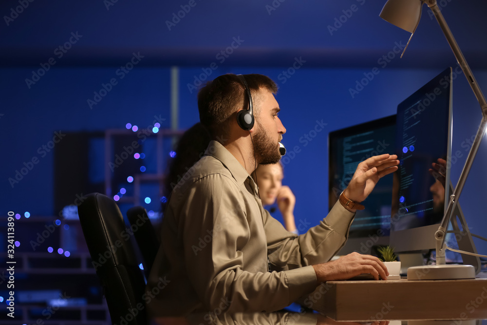 Technical support agents working in office at night