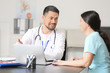 © Pixel-Shot - Male doctor working with patient in clinic